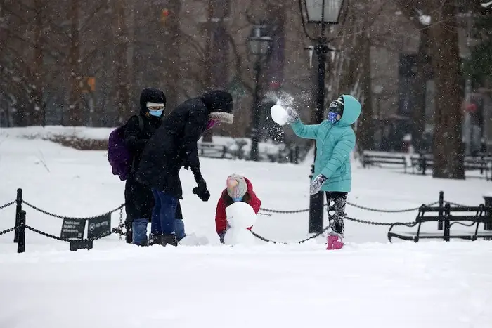 Two children and their parents play in the snow in Washington Square Park after a snow storm hit New York.